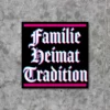 Produktbild für einen Sticker bzw. Aufkleber mit dem Motiv "Familie Heimat Tradition". Der Aufkleber hat einen schwarzen Hintergrund und eine Frakturschrift mit Glitch Effekt.