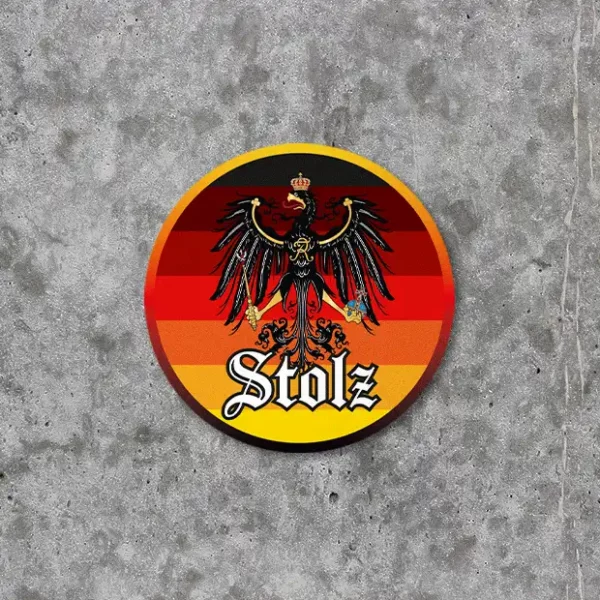 Produktbild für einen Stolzmonat-Sticker bzw. Aufkleber mit 6 mal 6 cm. Das Motiv ist rund und hat Farbabstufungen von Schwarz zu Rot zu Gold und das preußische Wappen mit Adler ist abgebildet als Symbol für nationalen Stolz. Das Ganze ist angelehnt an die progressive LGBTQ Stolzflagge. Unter dem Wappen steht das Wort "Stolz".